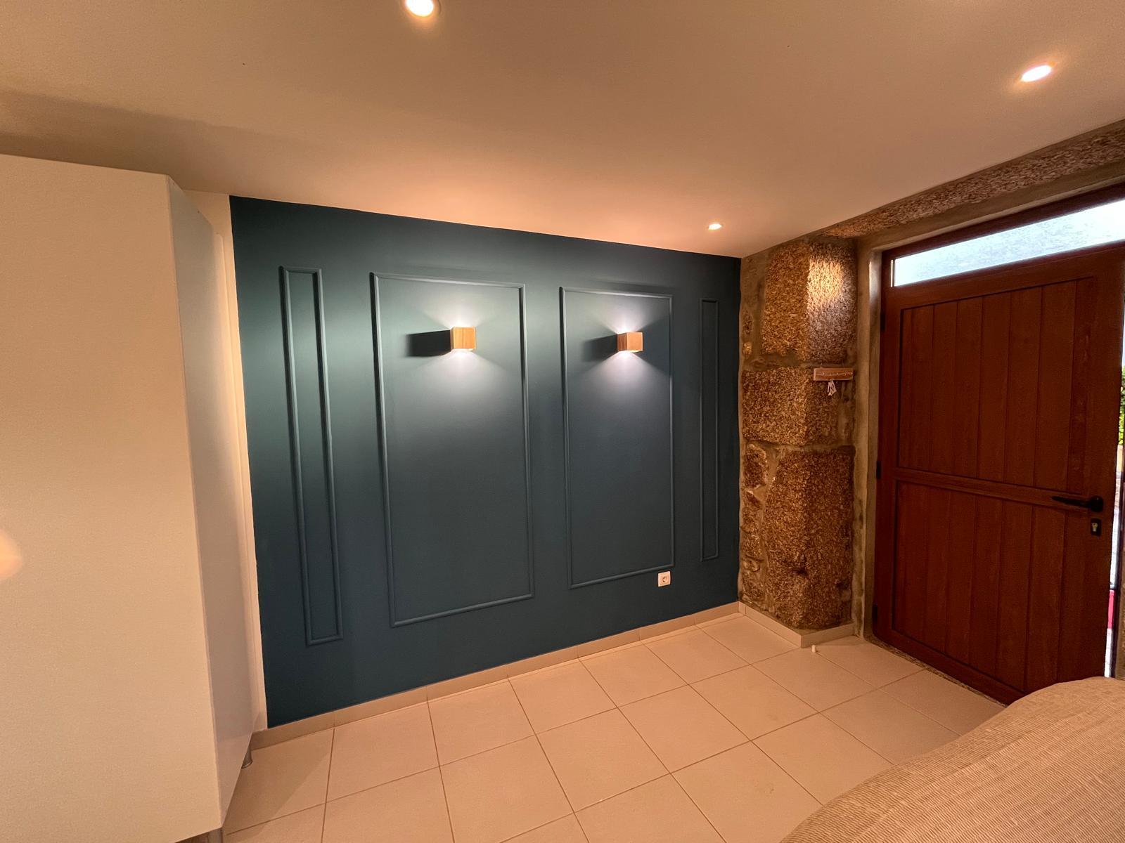 Entrada com parede navy painelada e apliques